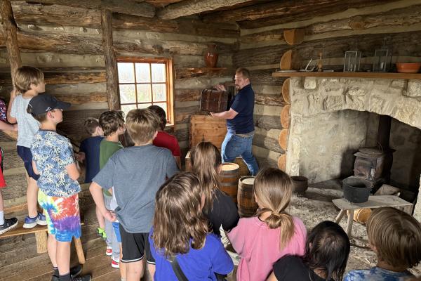 school aged summer campers in the log cabin