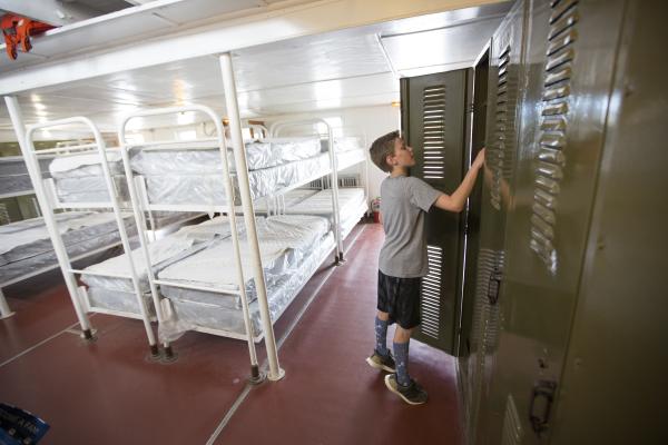 kid looking into locker in bunkroom