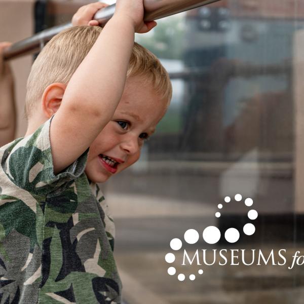 small boy looking at exhibit with Museums for All logo in the bottom right corner